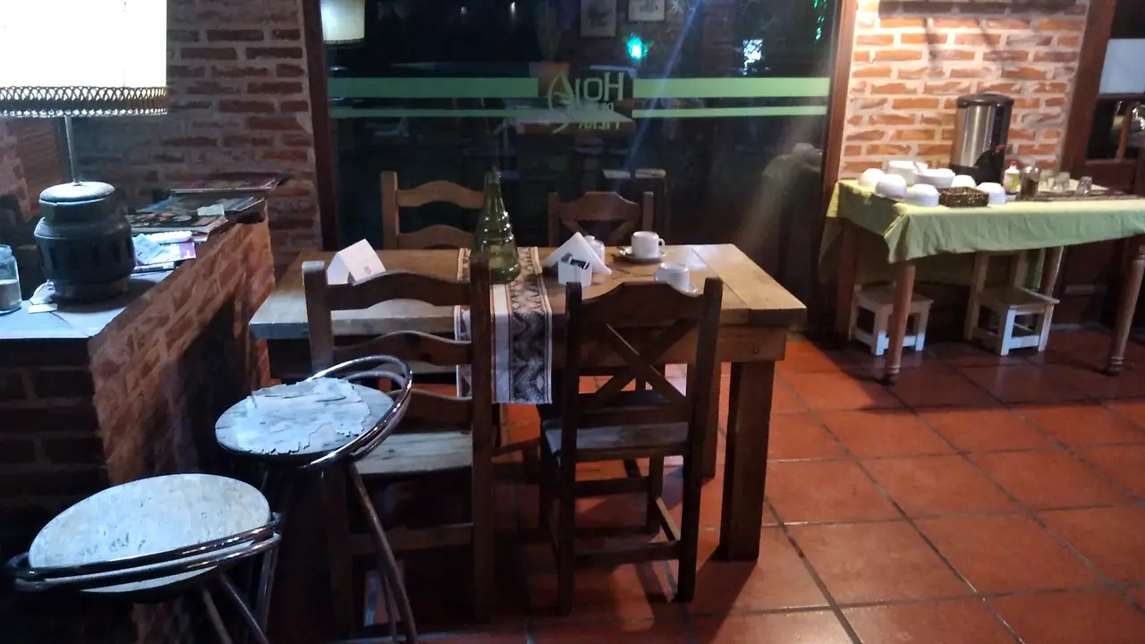 El Club House por dentro: ladrillo, madera y mesas para el desayuno.