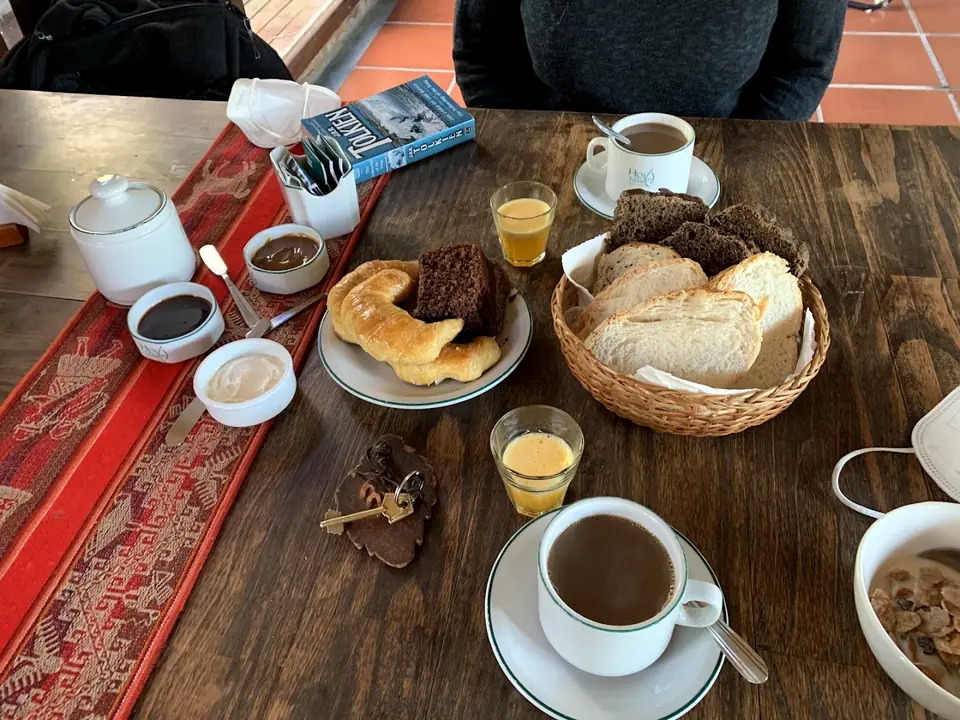 Desayuno servido: café con leche, medialunas, tostadas y mermeladas.