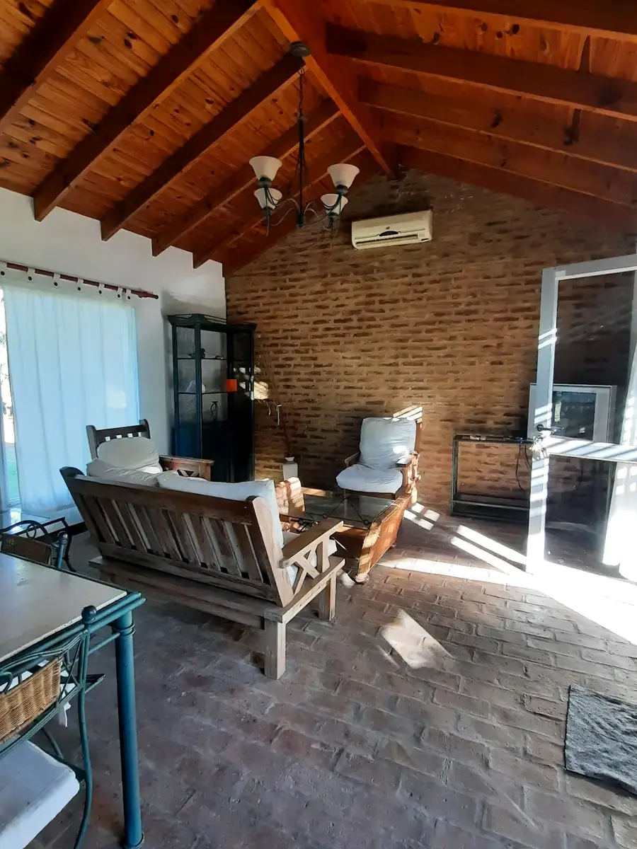 El living, con techo de madera a dos aguas, en El Álamo.