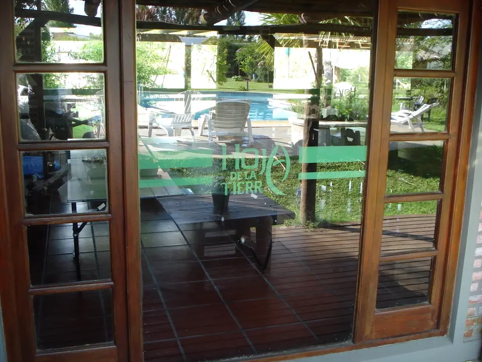 Los ventanales de madera del Club House, con la pileta del otro lado.