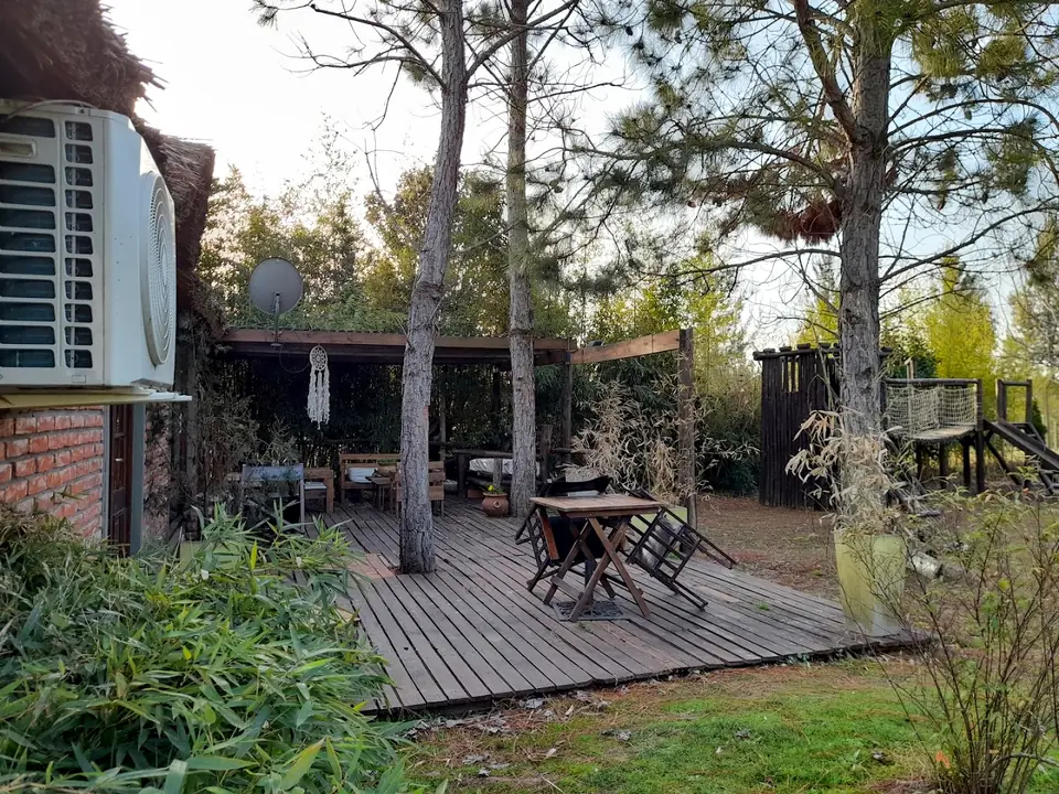 Un deck con mesas, junto a una de las casas.