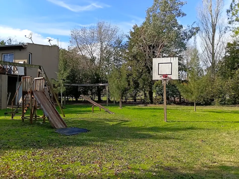 El área de juegos: hamacas, aro de básquet y el fuerte al fondo.